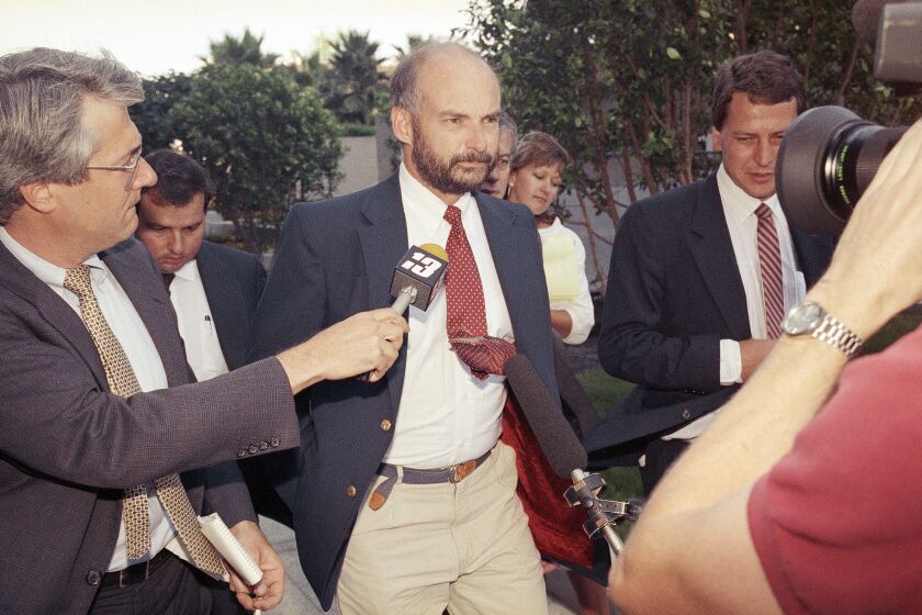 FILE - Former Exxon Valdez Capt. Joseph Hazelwood is surrounded by reporters as he leaves his re-licensing hearing in Long Beach, Calif., on July 25, 1990. Hazelwood, the captain of the Exxon Valdez oil tanker that ran aground more than three decades ago in Alaska, causing one of the worst oil spills in U.S. history, has died in July 2022, the New York Times reported. He was 75. (AP Photo/Alan Greth, File)