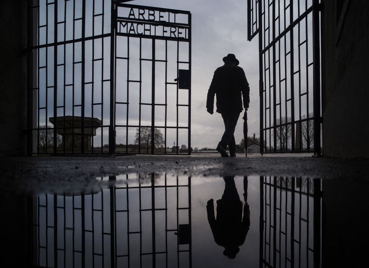 The silhouette of a man walking through the gate of the Sachsenhausen Nazi death camp north of Berlin