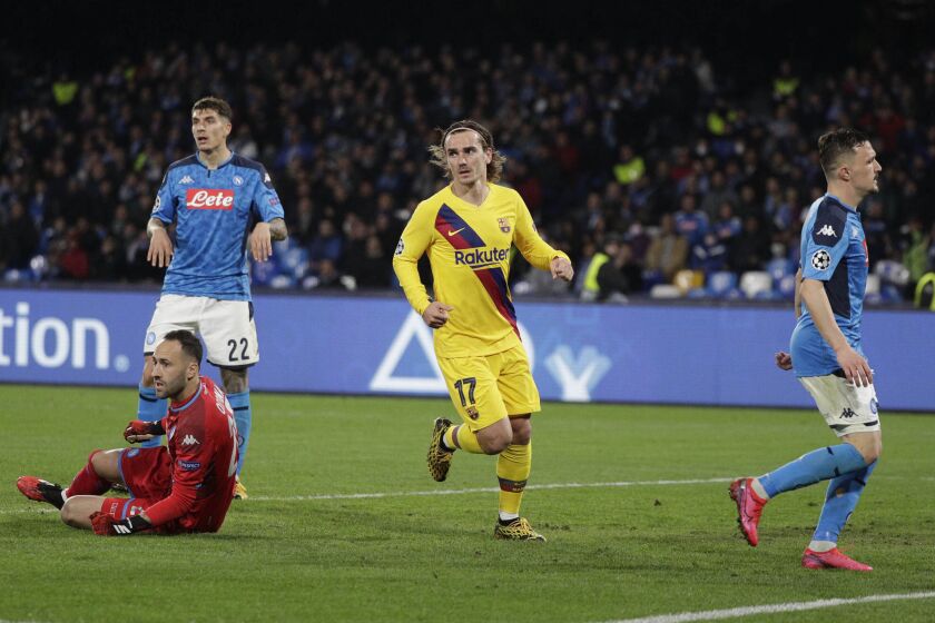 Barcelona's Antoine Griezmann, center, celebrates after scoring during the Champions League, Round of 16, first-leg soccer match between Napoli and Barcelona, at the San Paolo Stadium in Naples, Italy, Tuesday, Feb. 25, 2020. (AP Photo/Andrew Medichini)