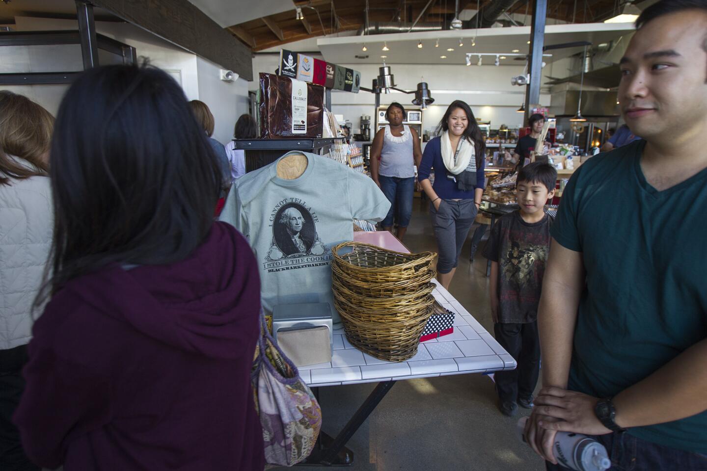 Customers participate in a cake walk, similar to musical chairs, where the winner takes home a cake a the Blackmarket Bakery open house on Saturday, January 25. The festivities are a celebration of the one-year anniversary of the bakery being at The Camp in Costa Mesa.