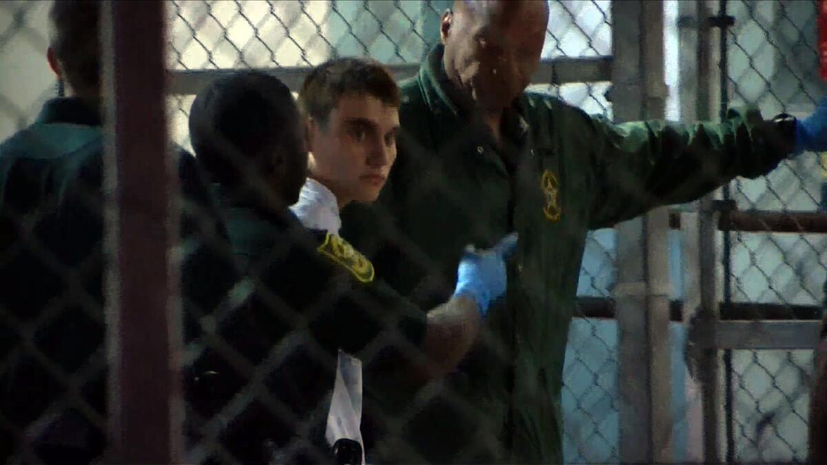 Shooting suspect Nikolas Cruz is led through a gate at Broward County Jail in southeast Florida.