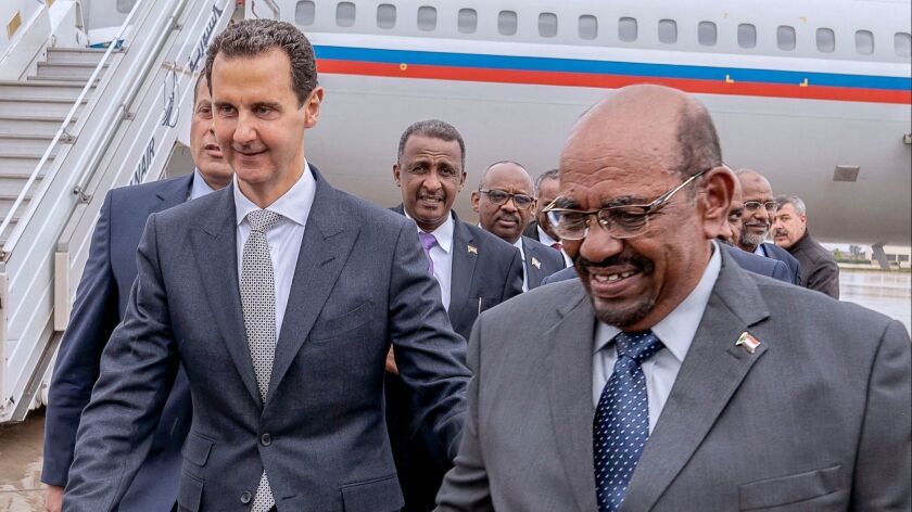 Sudanese President Omar Hassan Ahmed Bashir, right, arrives in Damascus, Syria, on Dec. 16 for an official visit with President Bashar Assad, left, in a photo from the state-run Syrian Arab News Agency.