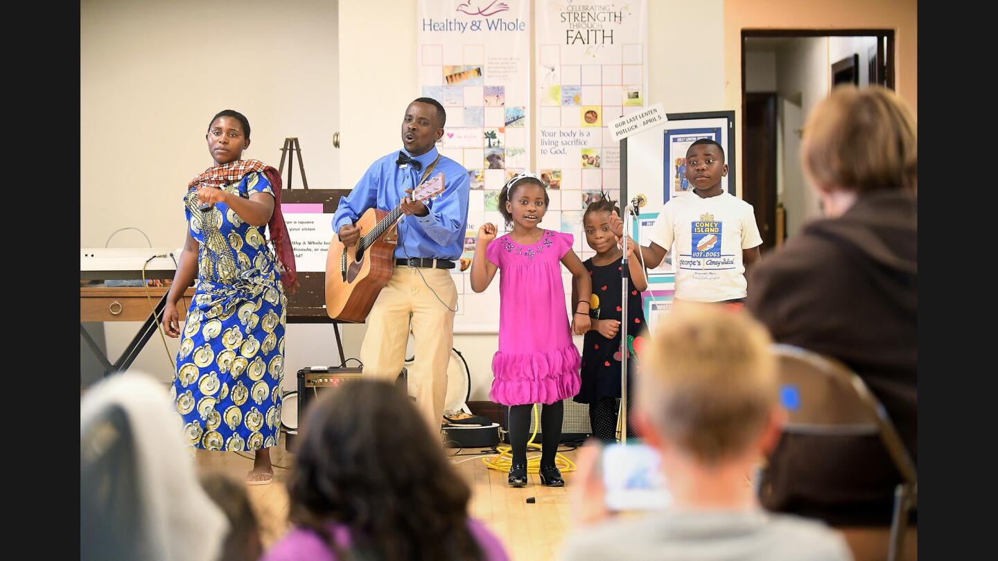 Bikyeombe Abwe, left, Joel Makeci Ebuela and three of their five children -- Maua Shukrani, 8, Betina Sango, 6, and Mtabi Makeci Ebuela, 12 -- perform gospel music at Holy Spirit Church in Missoula, Mont. The family arrived in the U.S. last September from a refugee camp in Tanzania.