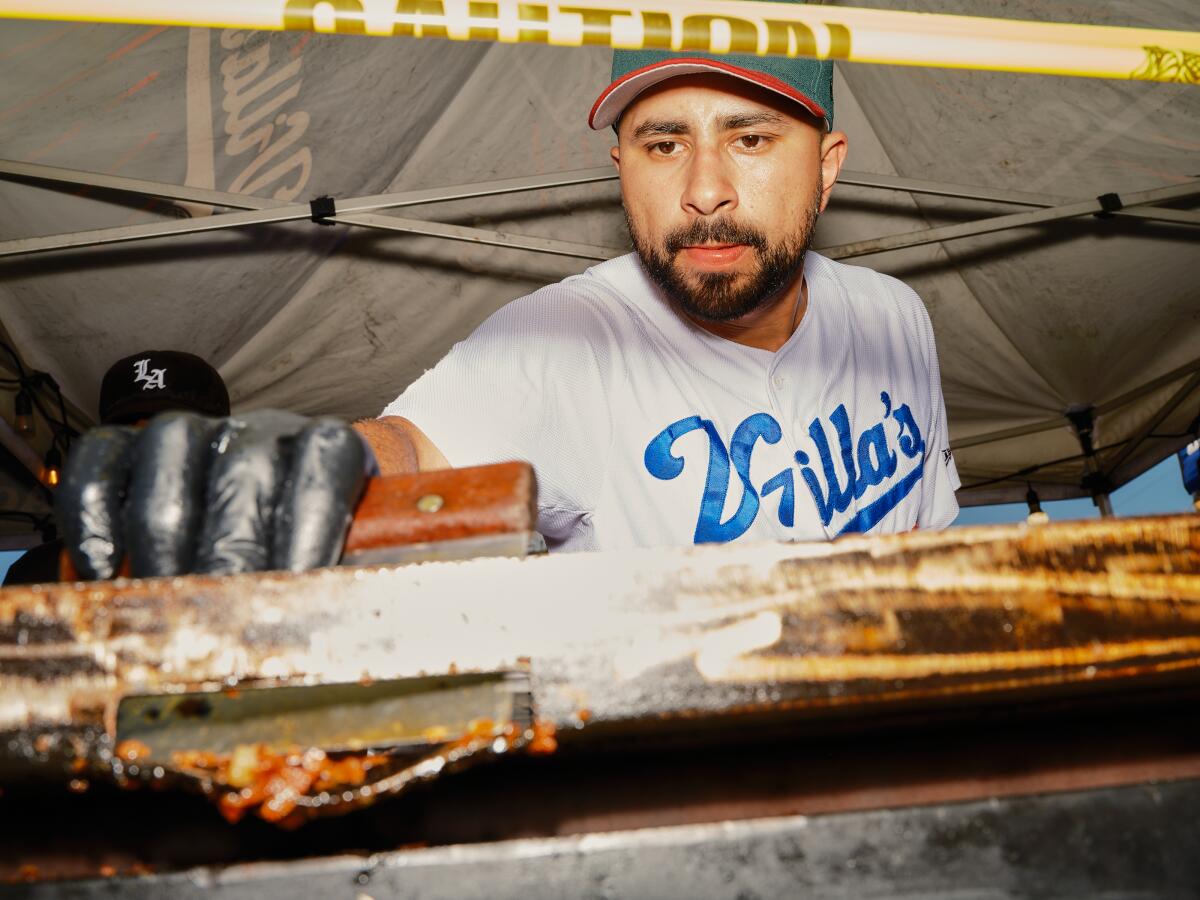 Villa's Tacos owner Victor Villa works the grill at his street taco stand in Highland Park