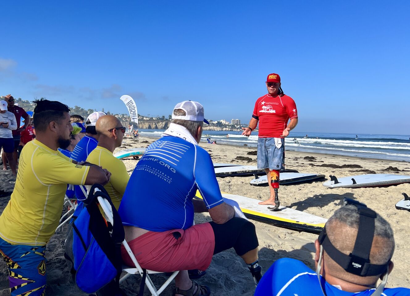 Dana Cummings of AmpSurf discusses surfing techniques with veterans during the National Veterans Summer Sports Clinic at La Jolla Shores.