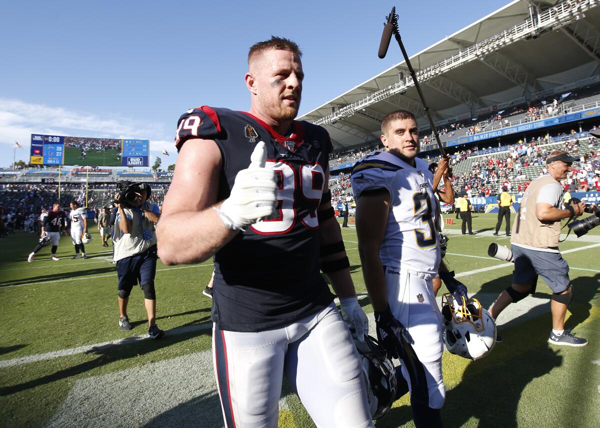 Houston Texans J.J. Watt and his brother Los Angeles Chargers Derek Watt walk off the field after playing each other in 2019.