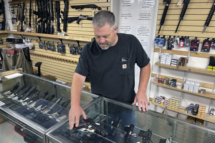 John Parkin, co-owner of Coyote Point Armory displays a handgun at his store in Burlingame, Calif., Thursday, June 23, 2022. California's top law enforcement official said that he is working with the governor and legislative leaders on legislation to keep dangerous people from carrying concealed weapons in public, despite a U.S. Supreme Court decision that imperils the state's current law. (AP Photo/Haven Daley)