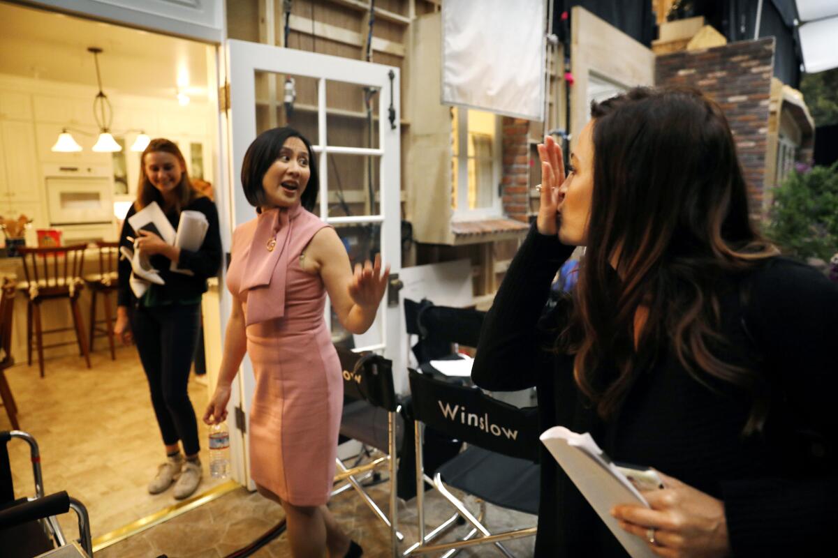 Executive producer Lauren Levy Neustadter, right, blows a kiss to Celeste Ng, center, author of "Little Fires Everywhere, " on set of Hulu's limited series adaptation.