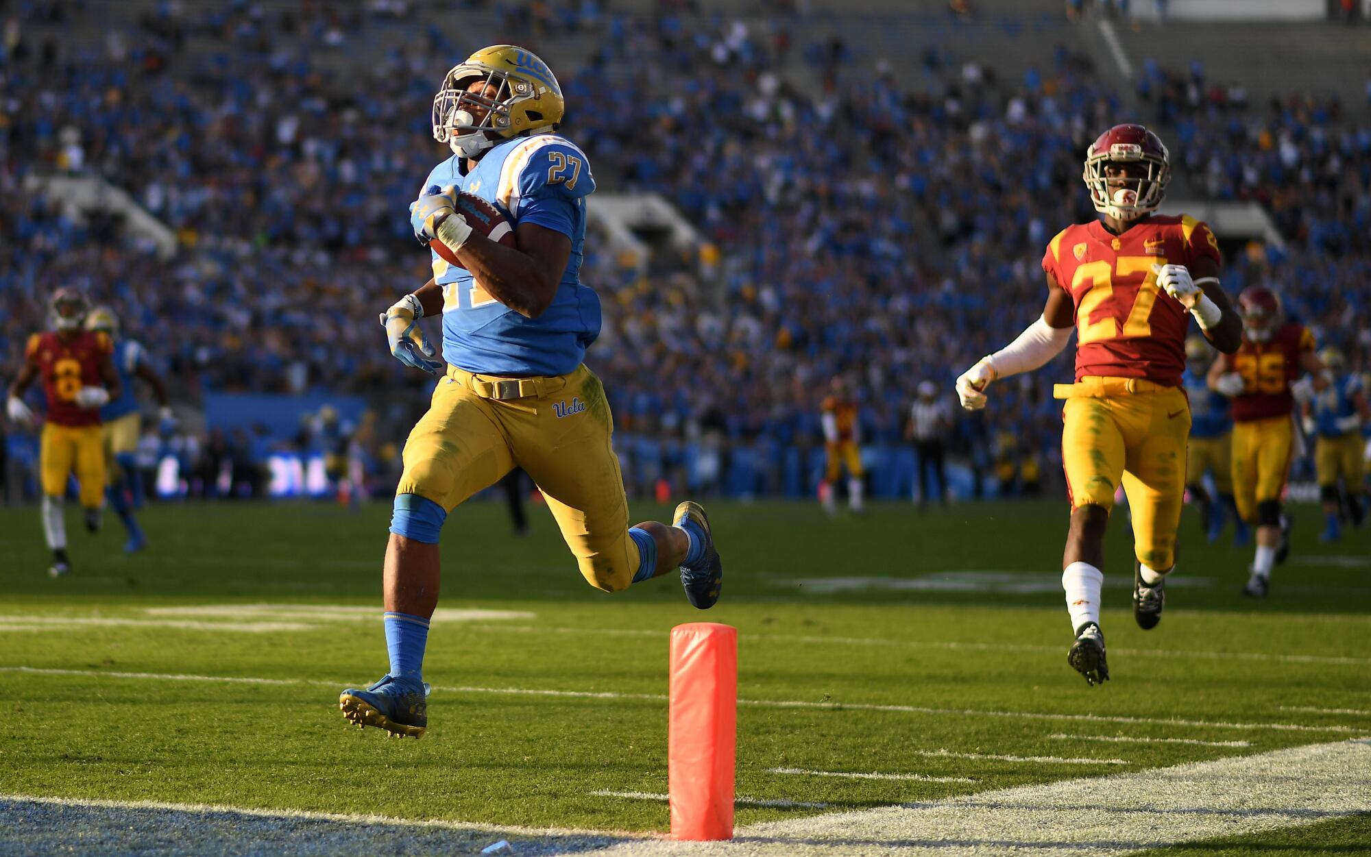 UCLA running Josh Kelley scores a 55-yard touchdown in front of USC defensive back Ajene Harris in 2018