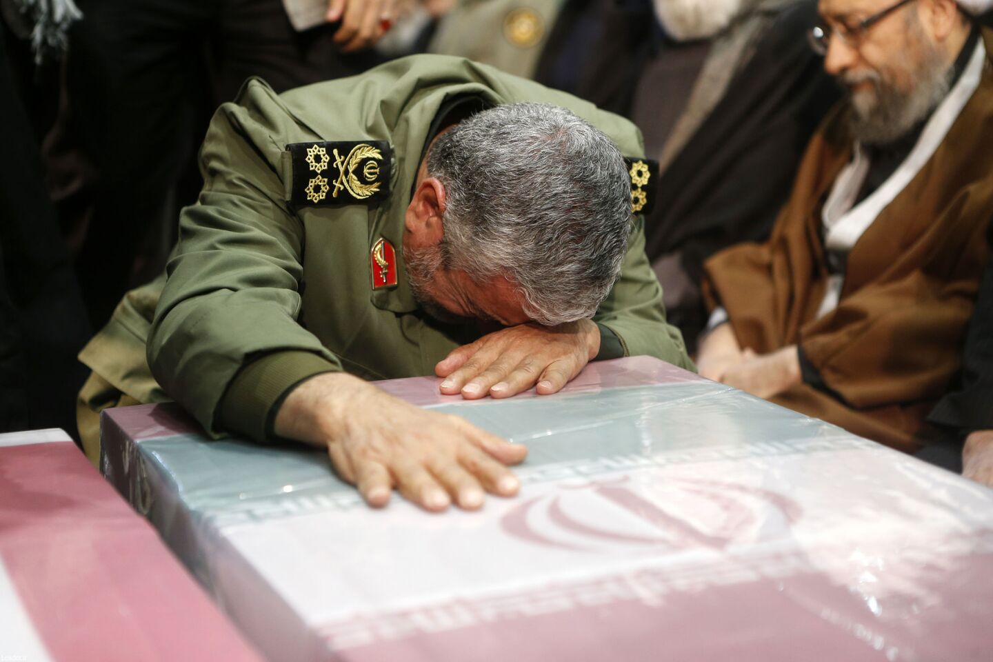Former Iranian Revolutionary Guards Corps chief Mohamad Ali Jafari prays over Suleimani's coffin.