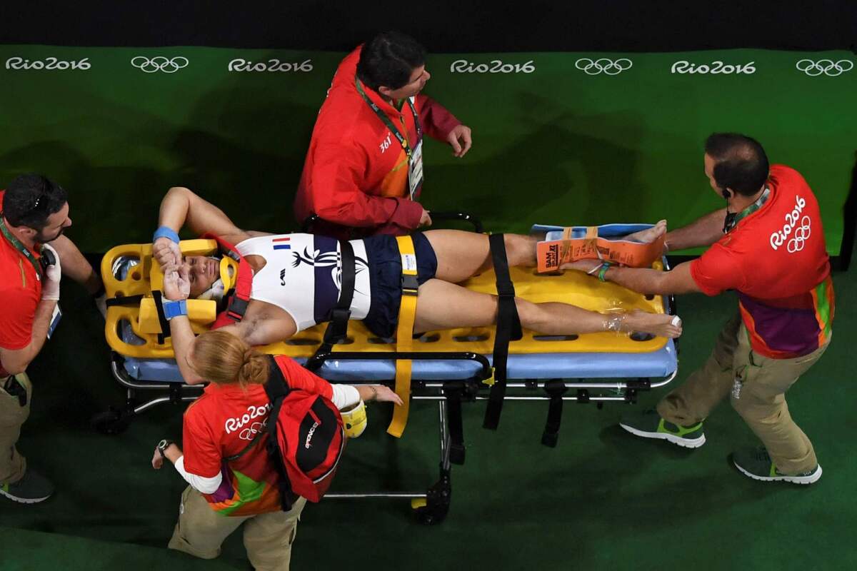 France's Samir Ait Said is stretchered off after breaking his left leg.