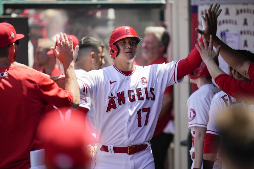 Los Angeles Angels designated hitter Shohei Ohtani (17) celebrates in the dugout with teammates after hitting a home run during the third inning of a baseball game against the Baltimore Orioles Sunday, July 4, 2021, in Anaheim, Calif. (AP Photo/Ashley Landis)