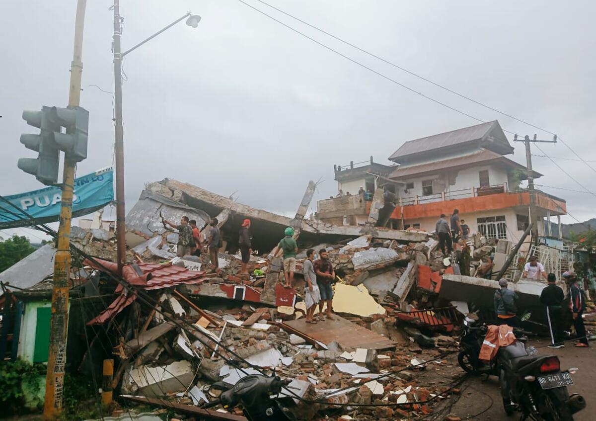 Residents survey damage in Indonesia's West Sulawesi province after Friday's earthquake. 