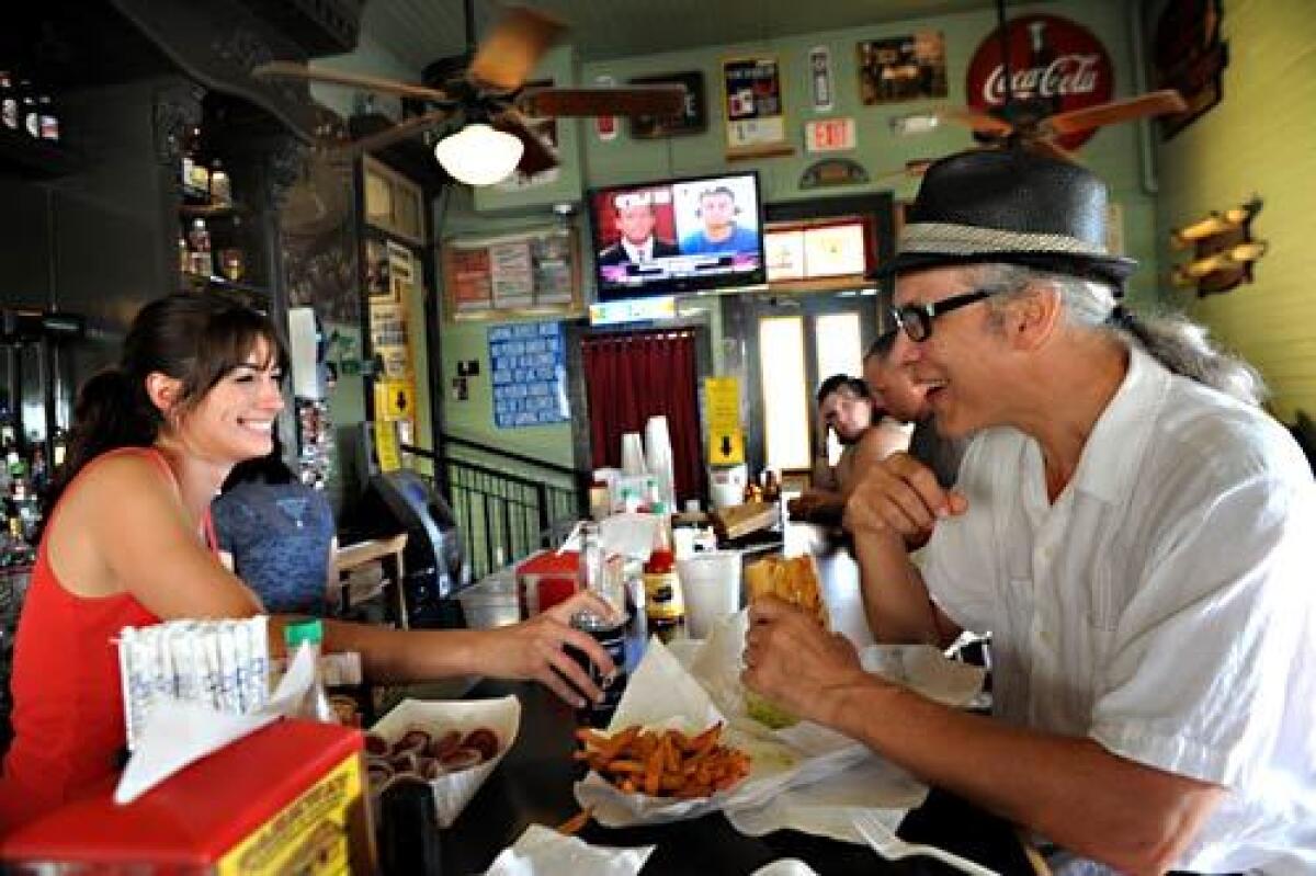 Alex Carter serves customer Mark McGrain a catfish po' boy and a root beer at the Parkway Bakery & Tavern.