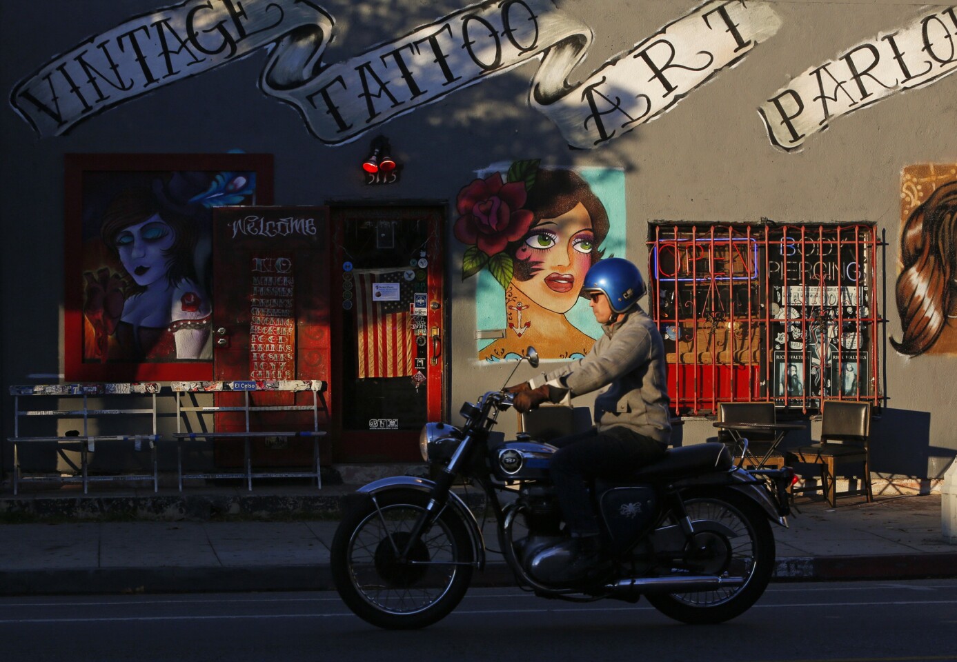 A motorcyclist passes the Vintage Tattoo Art Parlor on York Boulevard in the Highland Park neighborhood of Los Angeles.