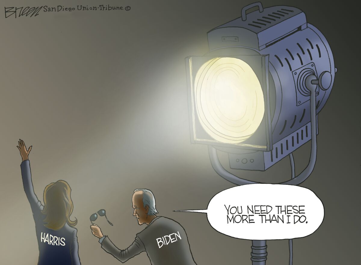 In this cartoon, Biden hands Harris his sunglasses in front of a giant spotlight saying "You need these more than I do."