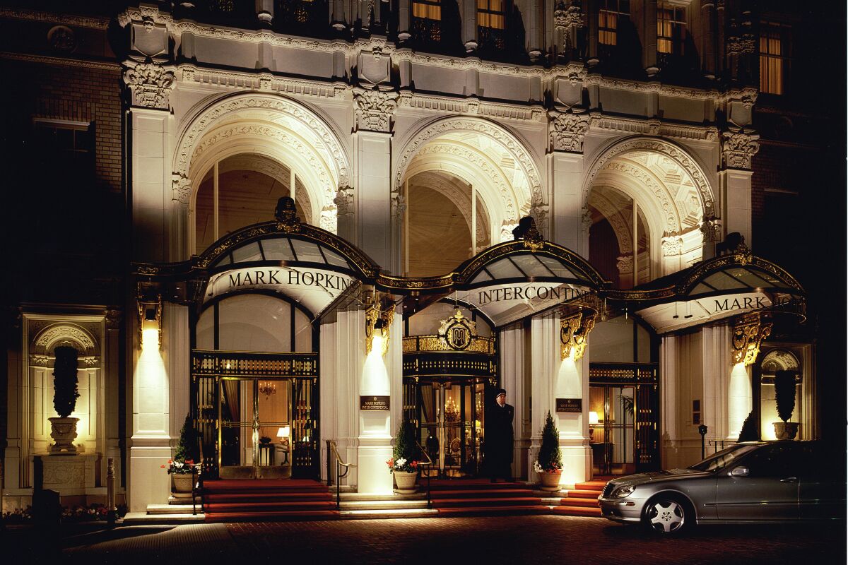 A view of the Intercontinental Mark Hopkins Hotel in San Francisco, its entrance lit up at night.