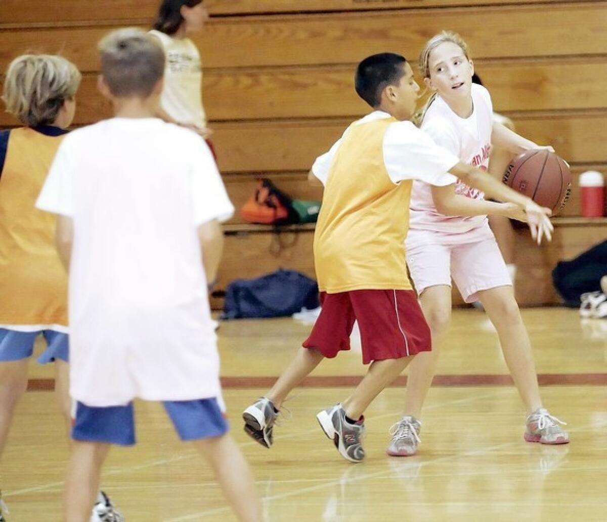 Claire Sheffer, 11 of Altadena, right, keeps the ball away from Anthony Stone, 10 of Pasadena, during a pick up game at the annual All-Sport Spartan All-Stars Camp.
