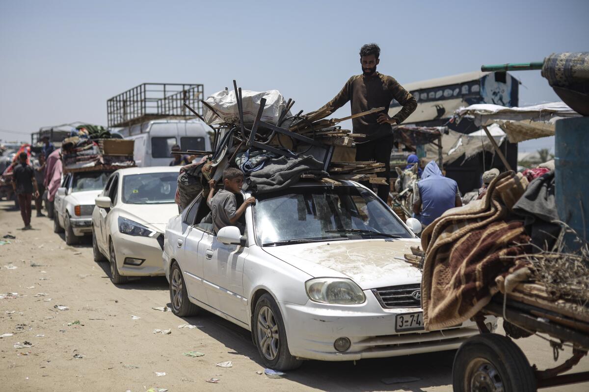 Palestinians arrive in the southern Gaza town of Khan Younis in vehicles with belongings in and on top of them.