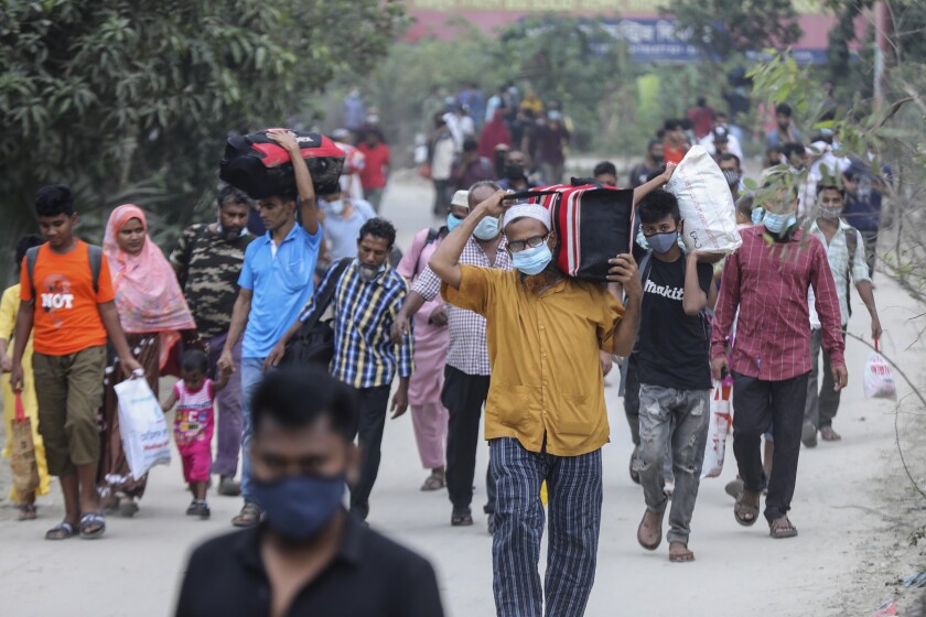 People leaving for their native places to celebrate Eid-al-Fitr arrive at the Mawa ferry terminal in Munshiganj, Bangladesh, Thursday, May 13, 2021. (AP Photo/Mahmud Hossain Opu)