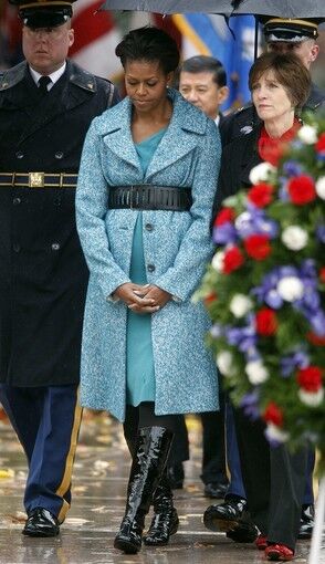 Mrs. Obama made the mixing of high and low a wardrobe signature. Here she belts a blue J. Crew coat over a Maria Pinto dress for the 2009 Veterans Day ceremony at Arlington National Cemetery.