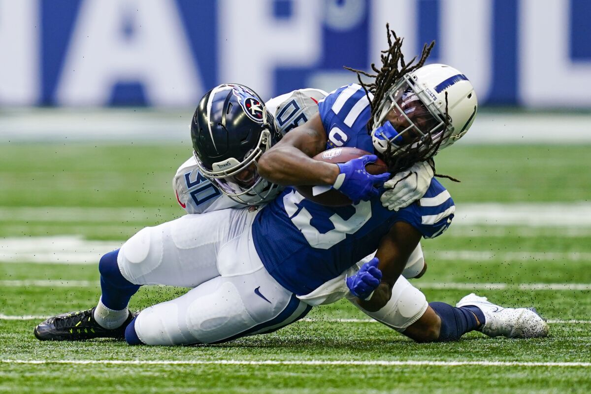 Indianapolis Colts wide receiver T.Y. Hilton (13) is tackled by Tennessee Titans cornerback Greg Mabin (30) after a catch in the first half of an NFL football game in Indianapolis, Sunday, Oct. 31, 2021. (AP Photo/Darron Cummings)