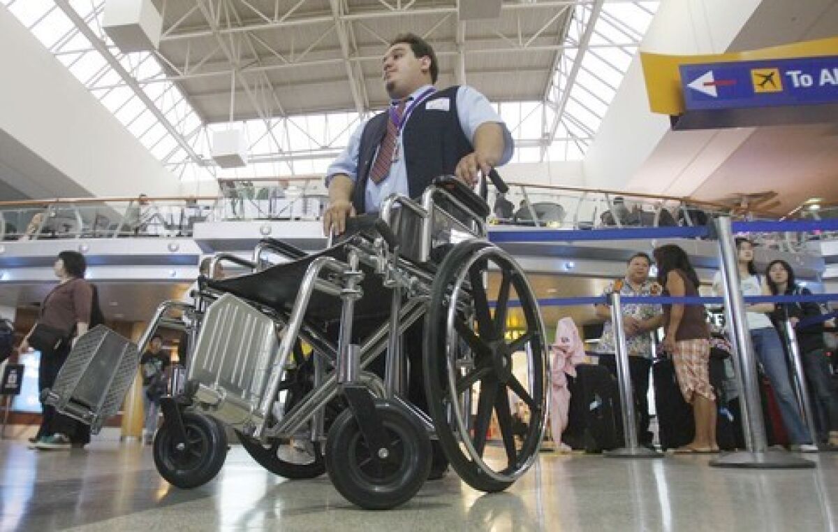 Nicholas Gonzales, a wheelchair attendant, waits for a passenger at LAX. The U.S. Transportation Department filed fewer civil penalties against airlines for violating aviation laws in the last three years, according to an analysis by The Times.