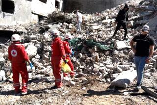 People along with rescue workers examine damage from an Israeli strike 