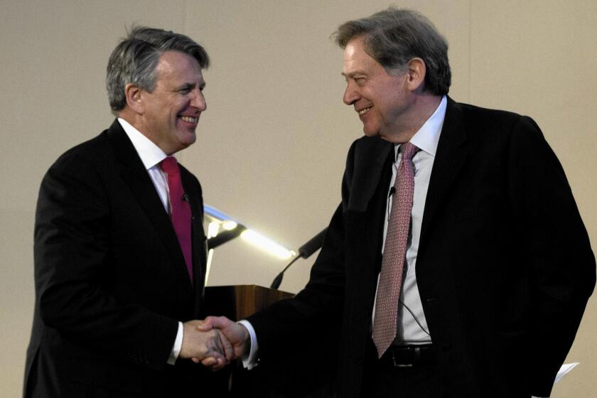 Ben van Beurden, CEO of petroleum giant Royal Dutch Shell, left, shakes hands with the chairman of BG Group, Andrew Gould, in a news conference announcing a $70-billion deal that could inspire copycat deals in the oil and gas industry as companies struggle to adjust to months of collapsing crude prices.