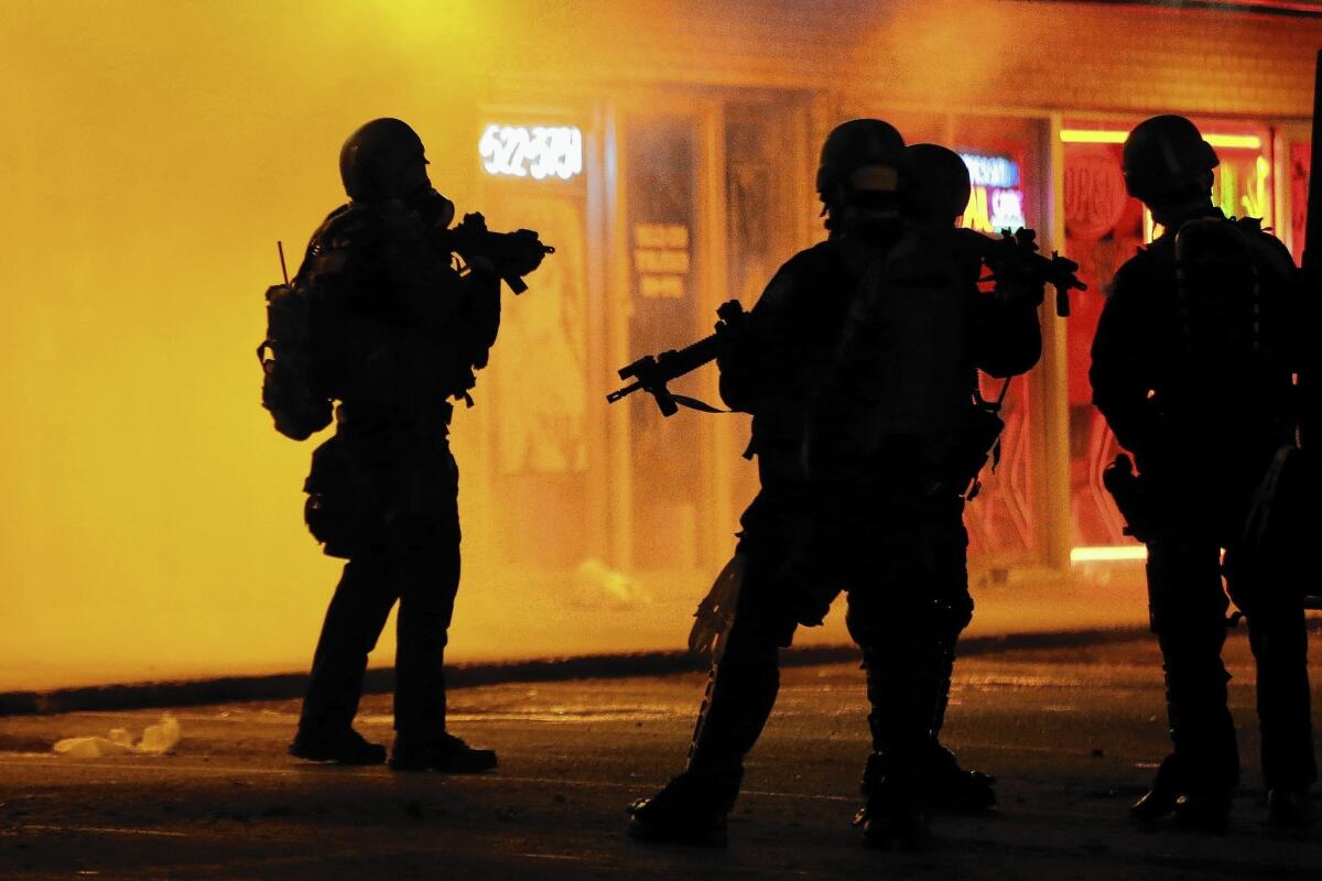 Police wait to advance after tear gas was used to disperse a crowd in Ferguson, Mo., on Aug. 17.