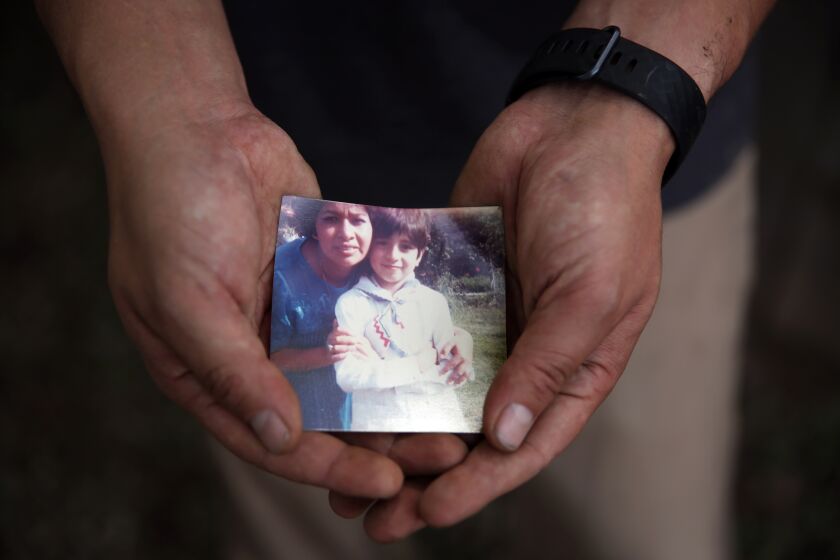 MONROVIA, CA-MARCH 31, 2020: Hugo Torres holds a picture of himself as a 7 year old with his mother Maria Luisa Castillo while at home on March 31, 2020 in Monrovia, California.Torres was 9 when his family went through the Mexico City earthquake of 1985. It was a tough time and he is using the lessons he learned from his mother back then during the coronavirus pandemic. (Photo By Dania Maxwell / Los Angeles Times)