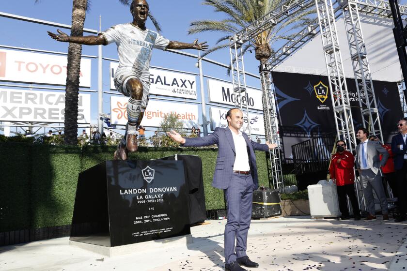 Former Galaxy player Landon Donovan poses with a statue in his likeness at Dignity Health Sports Park 