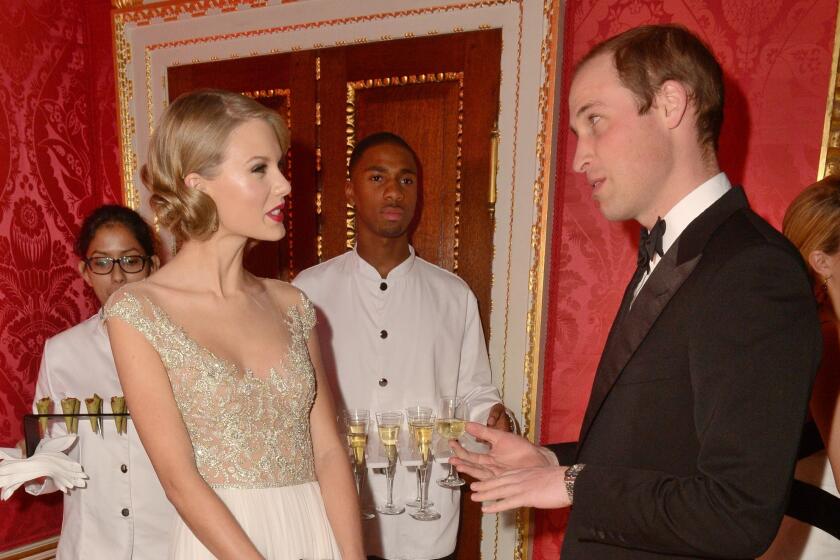 Singer Taylor Swift meets Britain's Prince William, Duke of Cambridge during the Winter White Gala dinner in aid of youth homeless charity Centrepoint at Kensington Palace in London on Nov. 26, 2013.