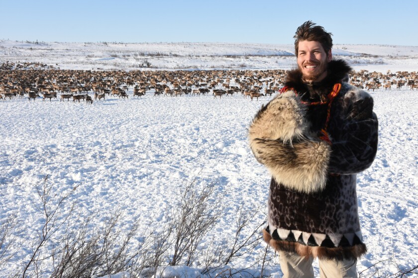 Kylik Kisoun Taylor with the Canadian reindeer herd on the frozen lake in the background.