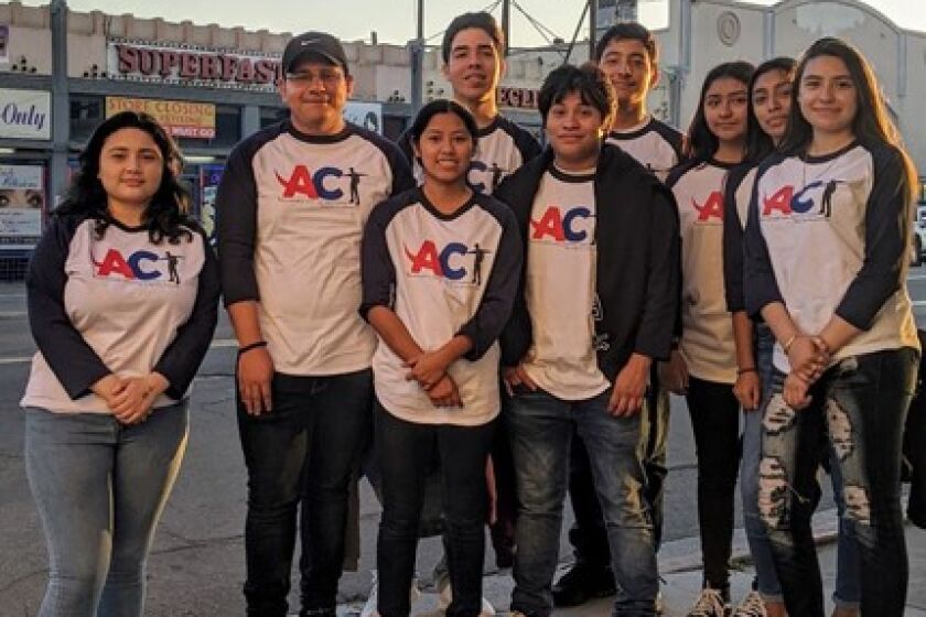 Youth from the Advocates for Change Today group pose near a "Escape the Vape" billboard in City Heights.