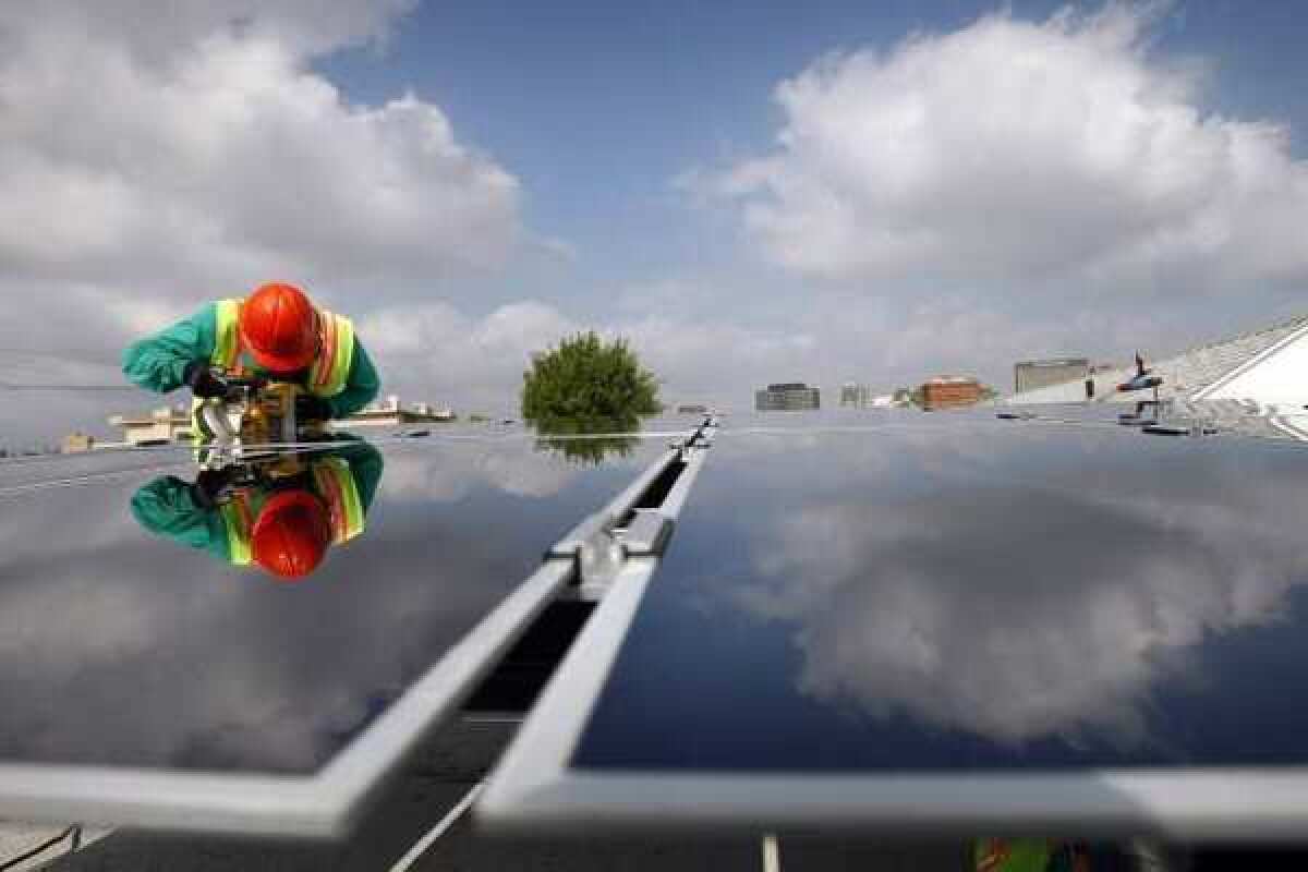 SolarCity Photovoltaics installer Victor Zapata assembles thin film technology solar panels at the home of Andrew Kin in Los Angeles.