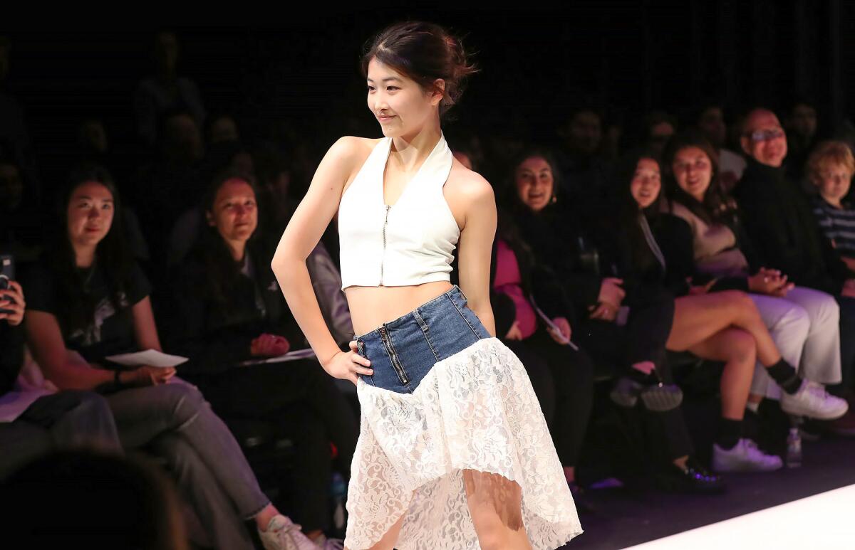 Student model Wenny Han walks the runway in Sage Hill School's Black Box Theater.
