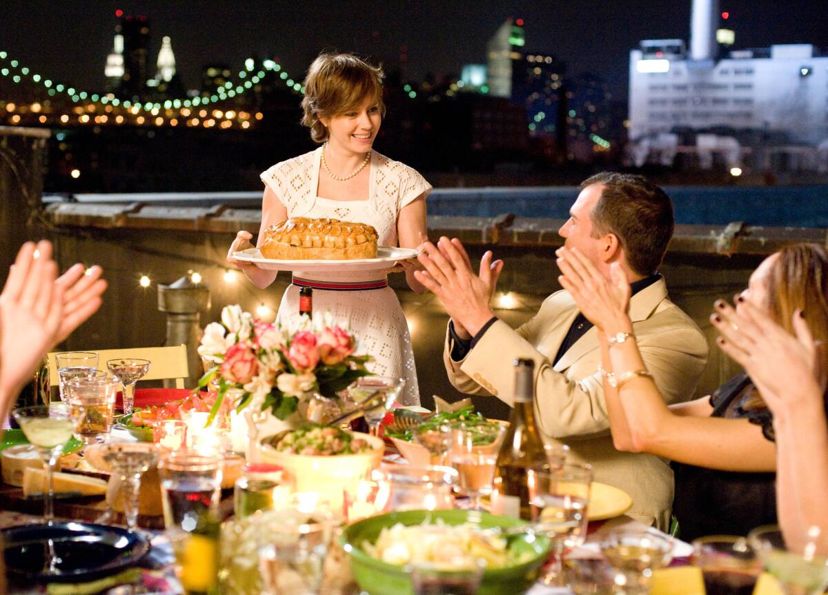 Amy Adams portrays Julie Powell serving a dish to applauding diners in a scene from "Julie & Julia" (2009). 