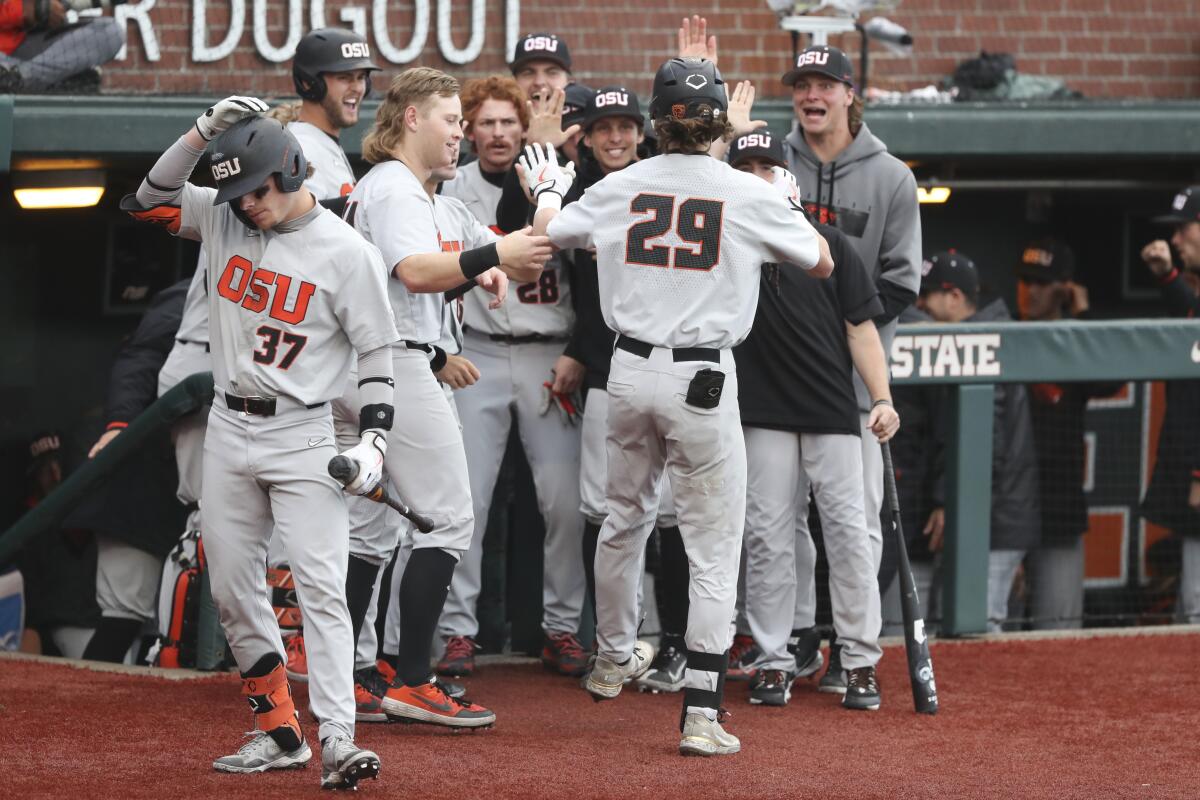 Oregon State players congratulate Jacob Melton on his home run during the fourth inning of an NCAA college baseball tournament super regional game against Auburn on Sunday, June 12, 2022, in Corvallis, Ore. (AP Photo/Amanda Loman)