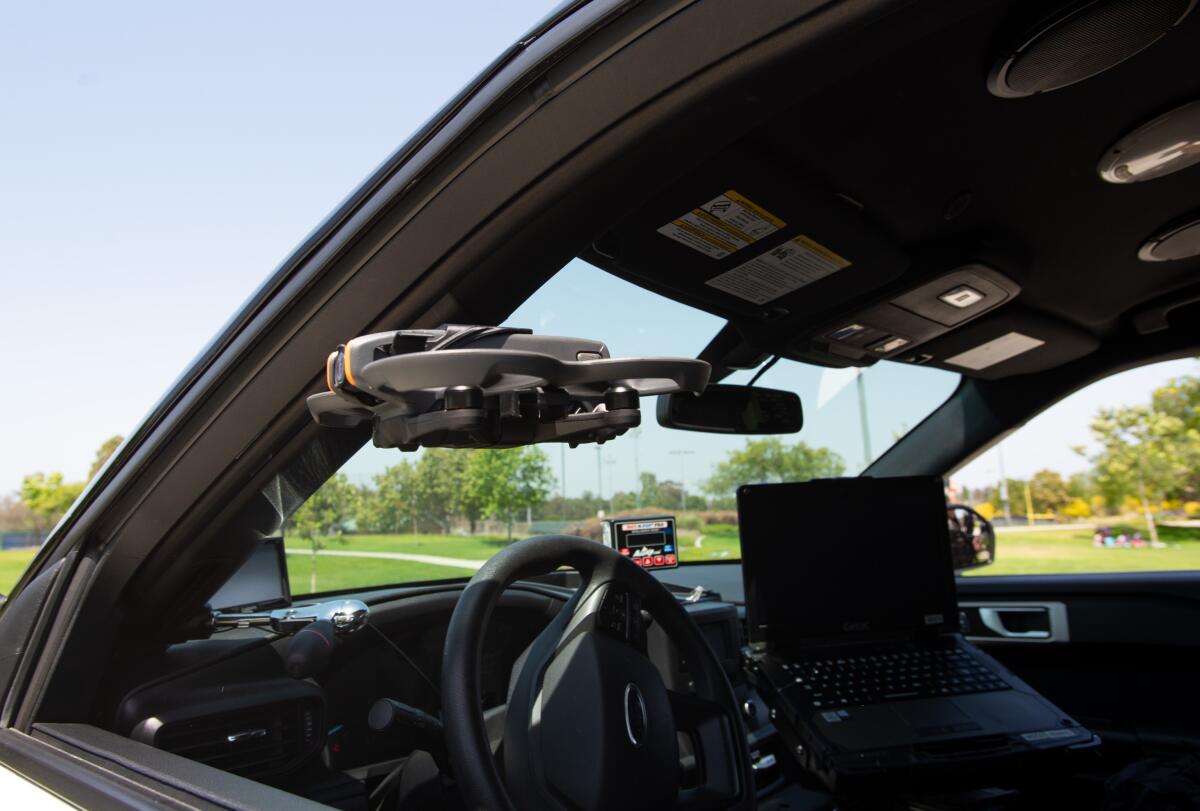 Fountain Valley Police Sgt. Brian Mosher maneuvers a drone through the windows of an SUV at the Fountain Valley Sports Park.