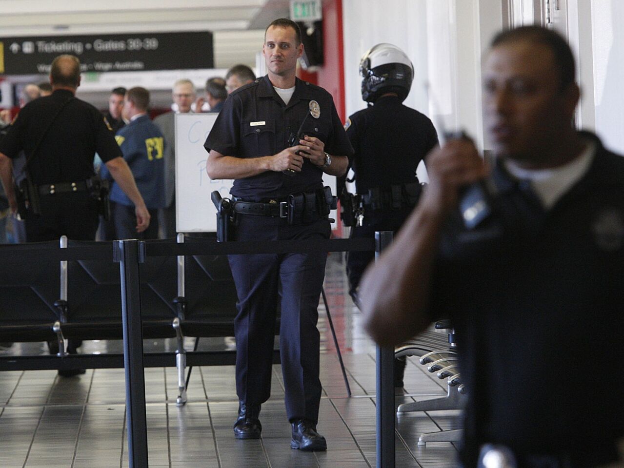 Law enforcement including the FBI, the Los Angeles Police Department, the Los Angeles Fire Department and LAX Airport Police gather in Terminal 3 at Los Angeles International Airport. A Transportation Security Administration agent was killed and several other people were wounded when a gunman opened fire at the airport. The attack caused widespread chaos, delaying flights and stranding thousands of passengers.