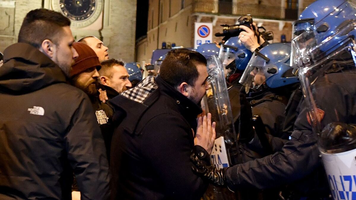 Supporters of the extreme right movement, the anti-immigrant Forza Nuova, or New Force, clash with police during an unauthorized demonstration on Feb. 8, 2018 in Macerata, Italy.