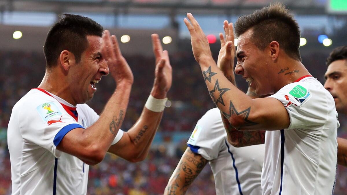 Chile's Eduardo Vargas, right, celebrates with teammate Mauricio Isla after scoring the team's first goal during a 2-0 victory over Spain in a Group B preliminary round World Cup match Wednesday.