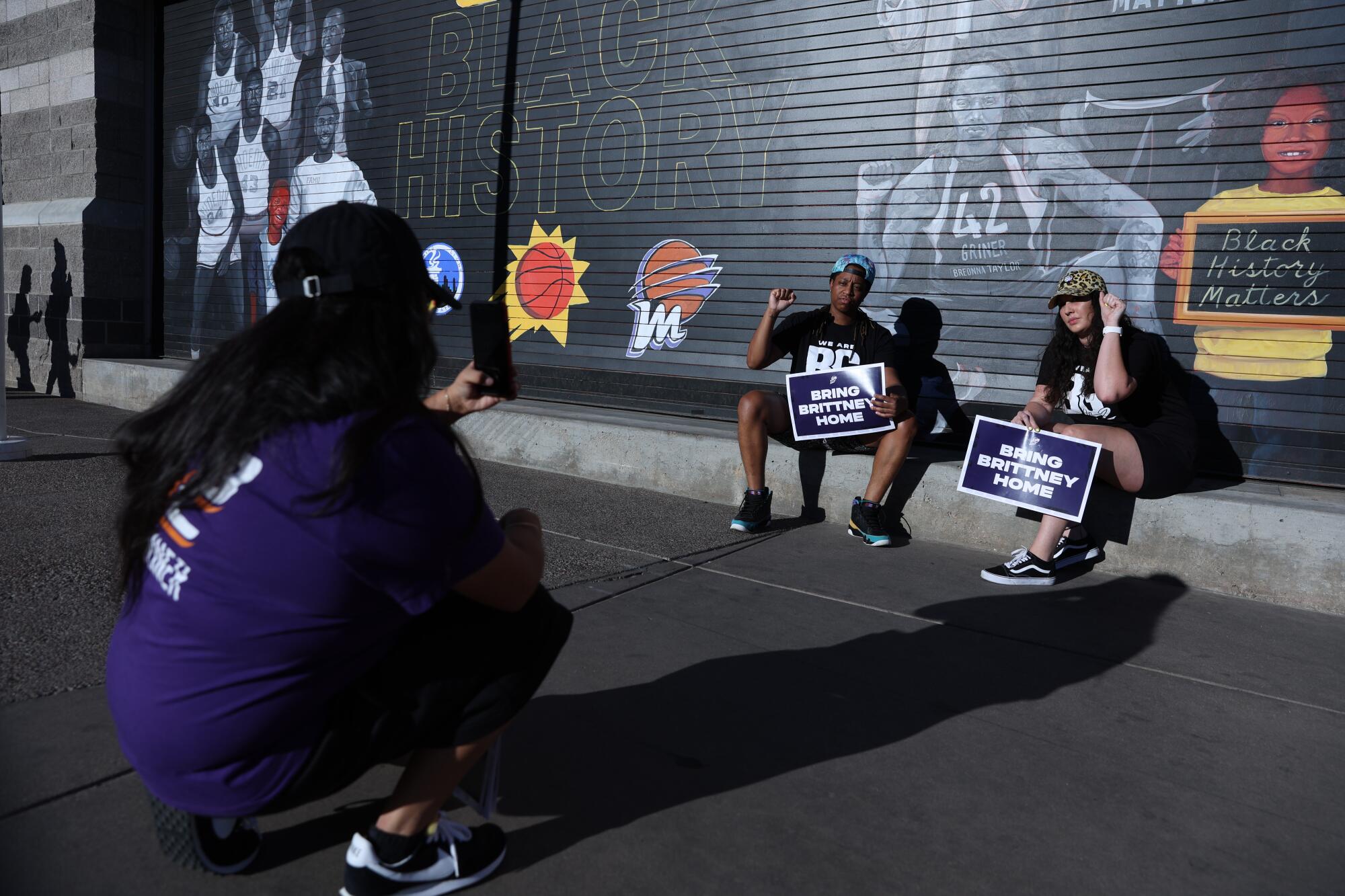 Supporters pose with a mural depicting Brittney Griner following a rally 