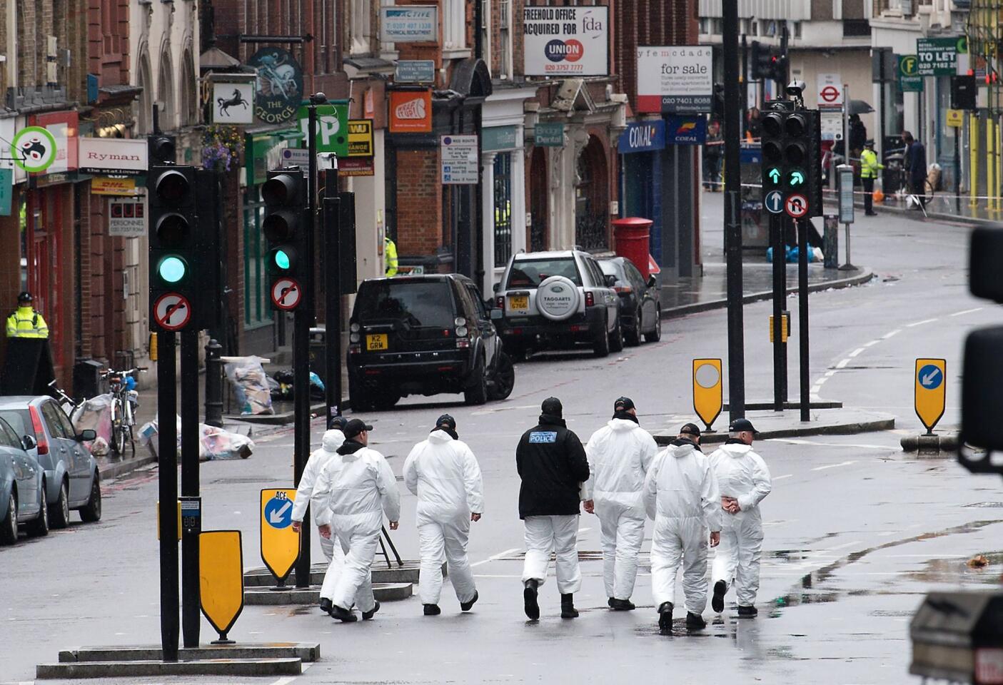 Police forensic officers on Tuesday work on Borough High Street, close to Borough Market, where the attackers stabbed people Saturday night.