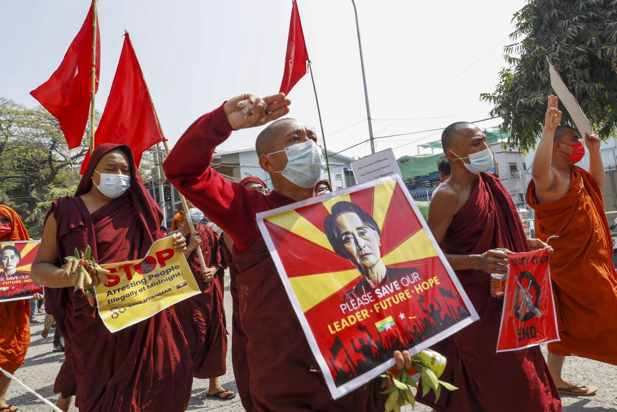 People march with signs in Myanmar.