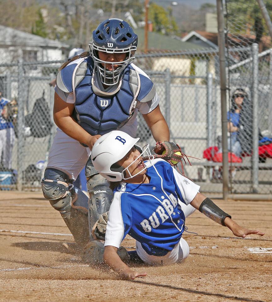 Burbank's Erika Montoya is tagged out by Crescenta Valley's catcher Izzy Jamgotchian in a Pacific League softball game at Crescenta Valley High School on Tuesday, March 26, 2019.