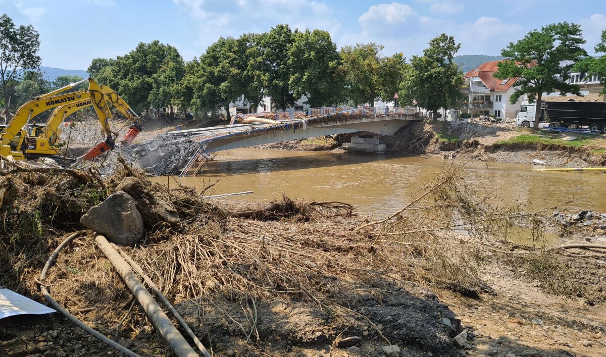 Debris litters the riverbank as workers use heavy machinery in Ahrweiler, Germany.