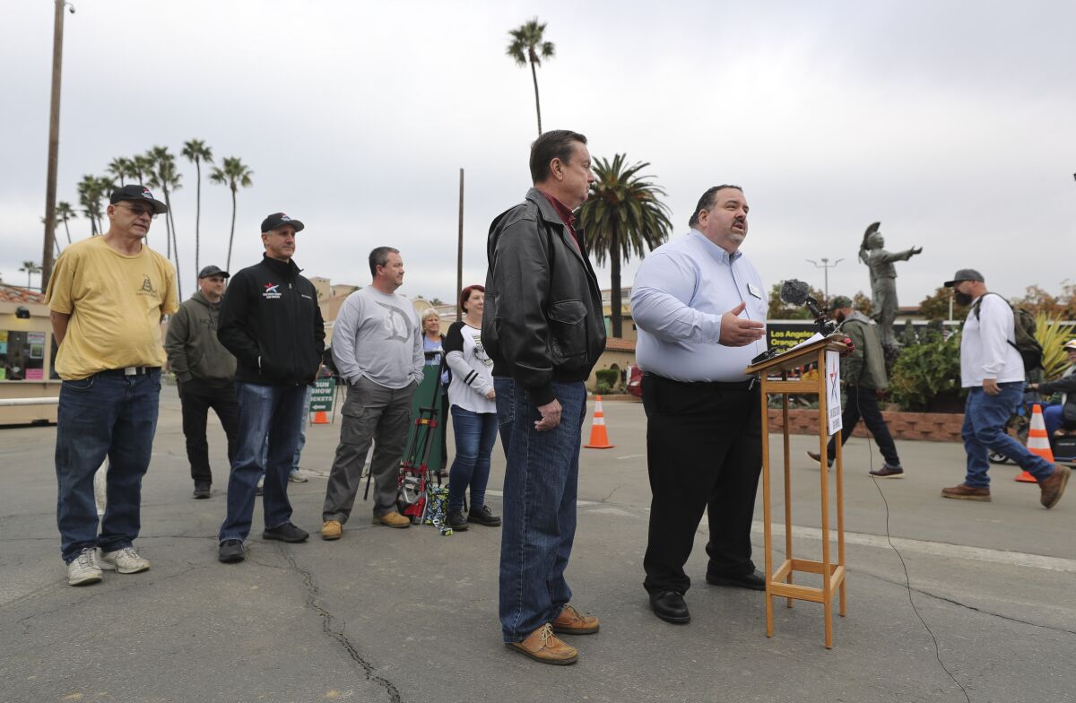 As people, right, head to the Crossroads of the West Gun show, San Diego County Gun Owners Executive Director Michael Schwartz holds a news conference and rally in support of the event. The group also endorsed former Sen. Joel Anderson, left, for the county Board of Supervisors.