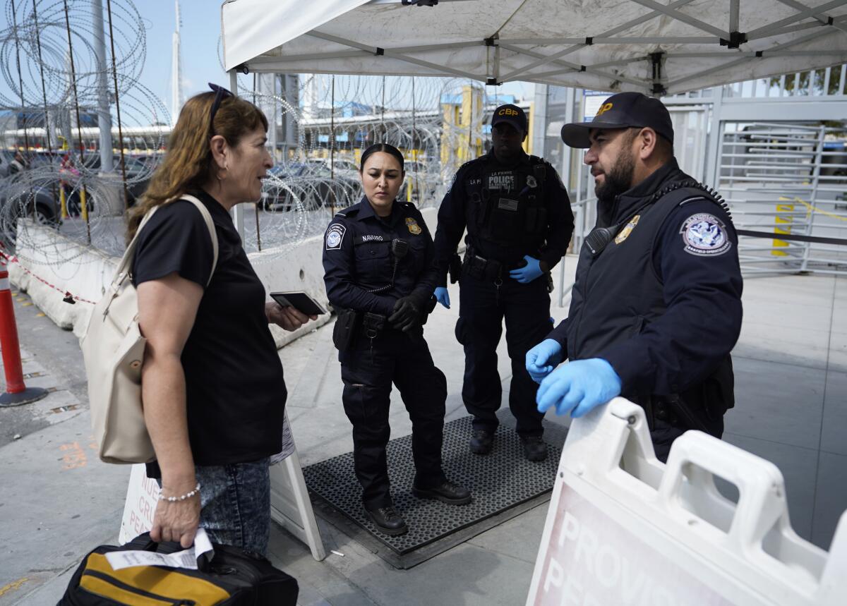 A woman speaks with U.S. Customs and Border Protection officers, pleading her case to be allowed to cross at the San Ysidro Pedeast border crossing.